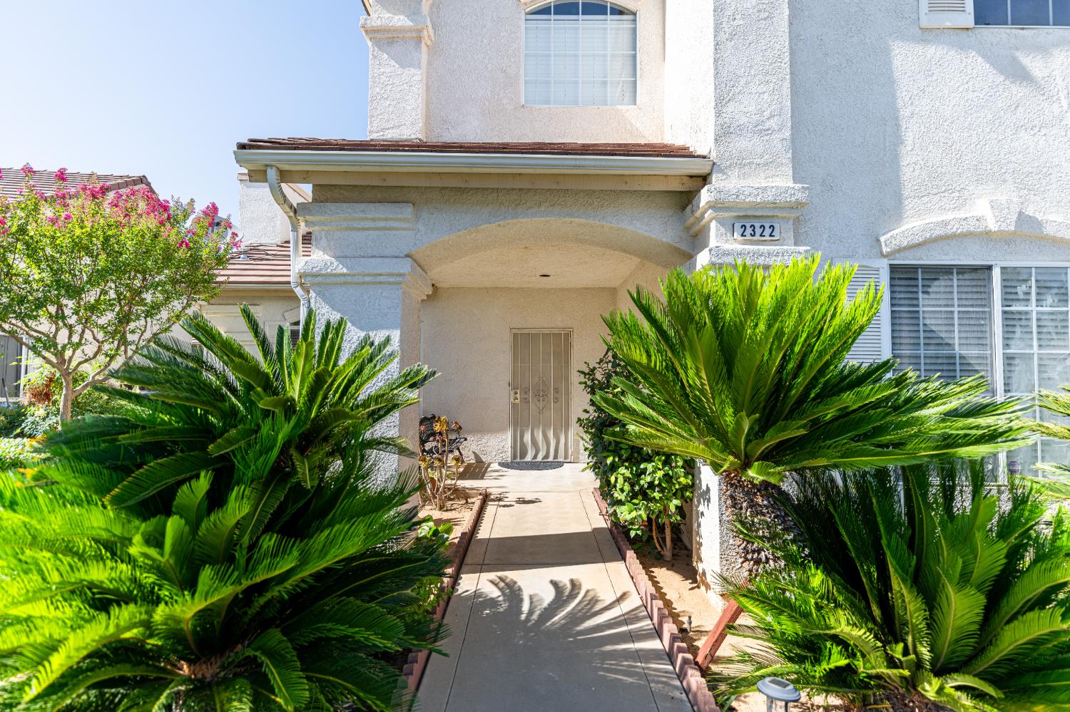 2322 East Revere Road Fresno, CA 93720 - Photo 4 of 33 a view of a house with a small yard and plants