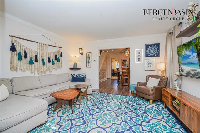 a living room with furniture a flat screen tv and a table