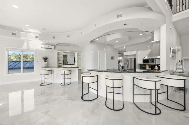 a kitchen with stainless steel appliances granite countertop a sink a stove and a table