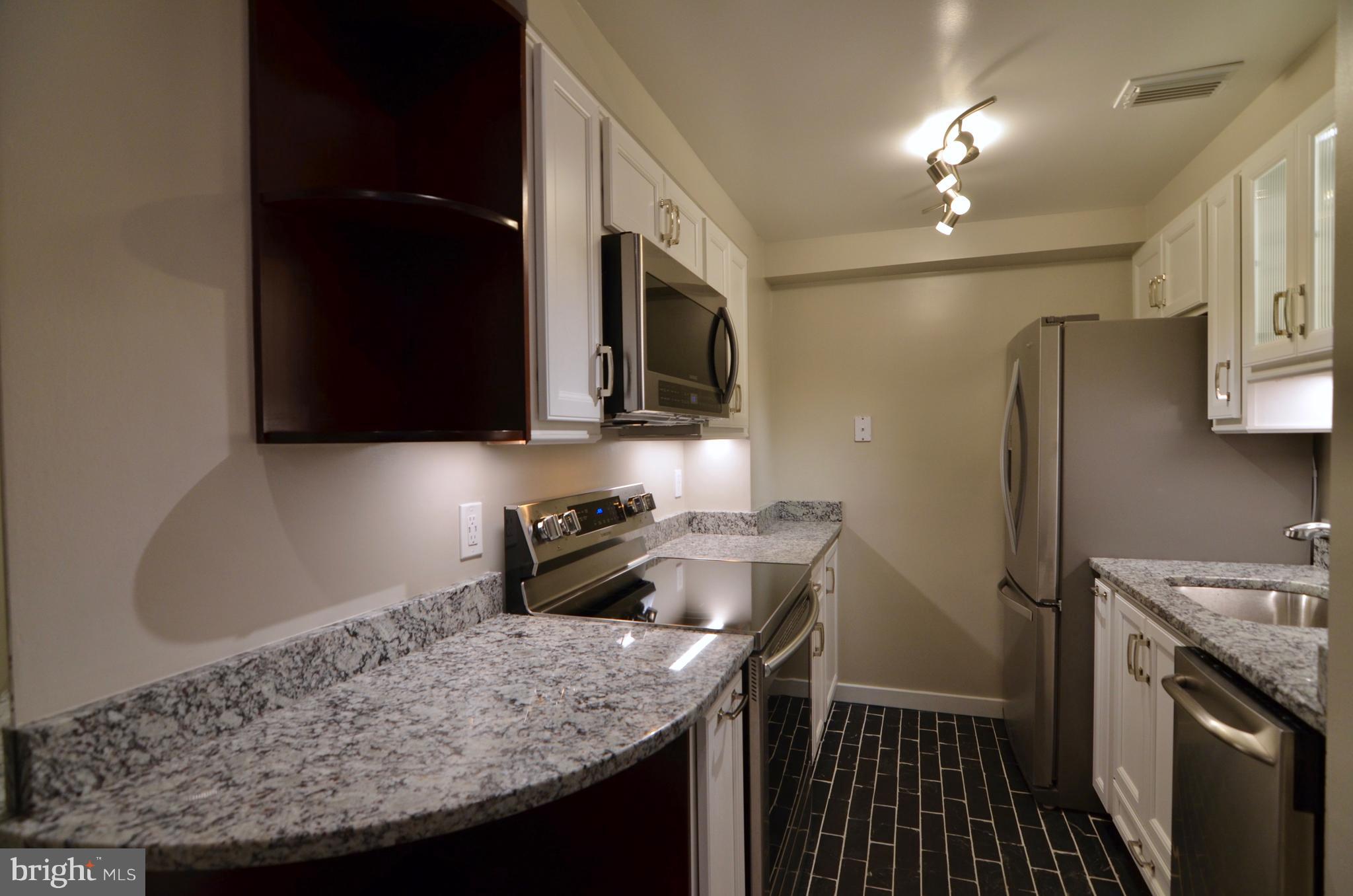 2114 N Street Northwest, Unit 2 Washington, DC 20037 - Photo 4 of 24 a kitchen with stainless steel appliances granite countertop a sink stove and refrigerator