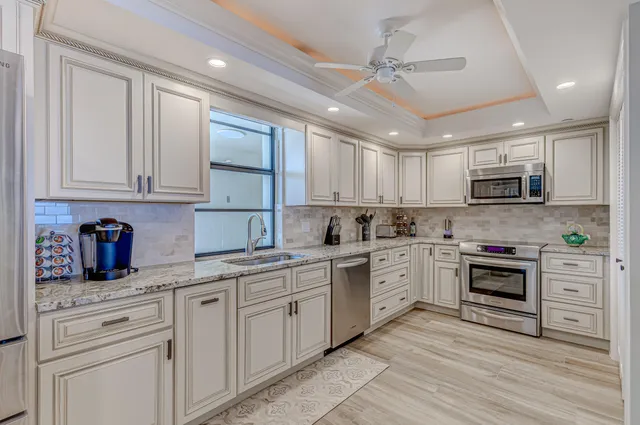 a large kitchen with cabinets stainless steel appliances and a window