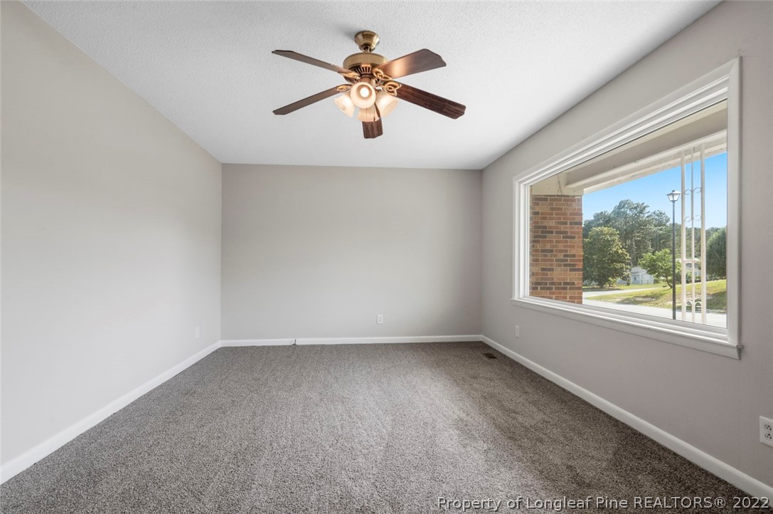 6614 Wake Forest Road Fayetteville, NC 28311 - Photo 11 of 48 an empty room with a window and a ceiling fan