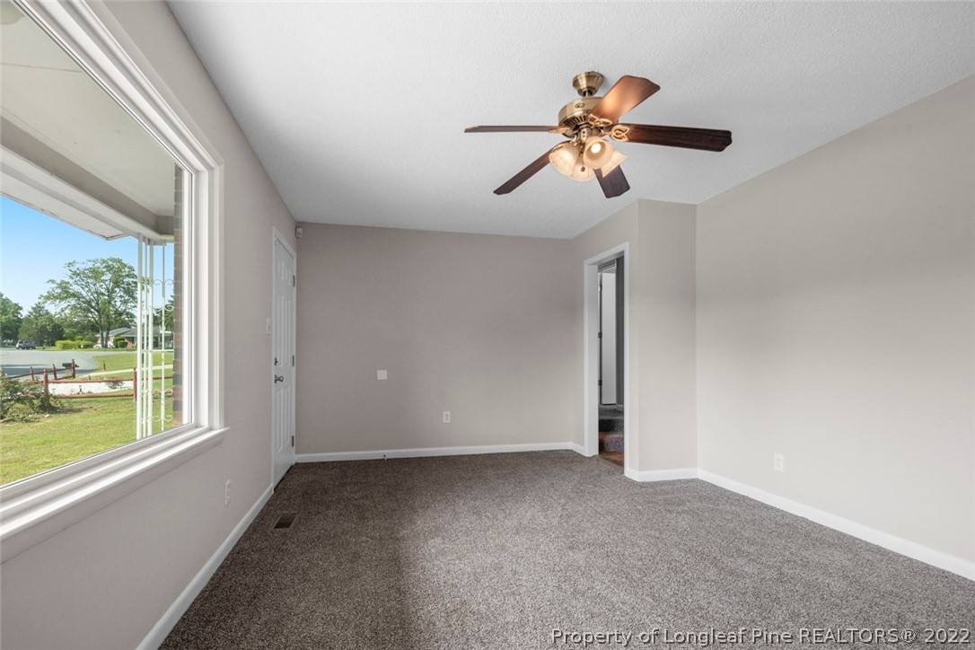 6614 Wake Forest Road Fayetteville, NC 28311 - Photo 12 of 48 a view of empty room with wooden floor and fan