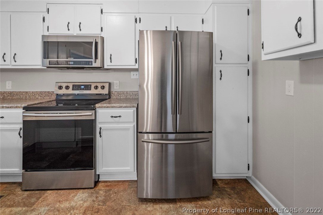 6614 Wake Forest Road Fayetteville, NC 28311 - Photo 18 of 48 a kitchen with cabinets and stainless steel appliances