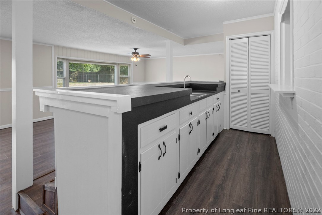 6614 Wake Forest Road Fayetteville, NC 28311 - Photo 26 of 48 a kitchen with granite countertop a sink and cabinets