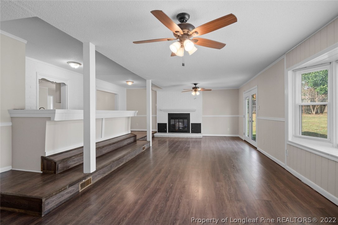 6614 Wake Forest Road Fayetteville, NC 28311 - Photo 28 of 48 a view of a livingroom with a ceiling fan wooden floor and a kitchen