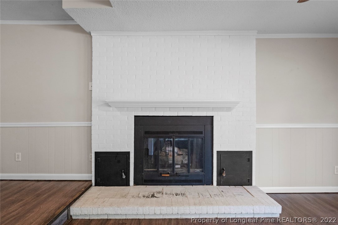 6614 Wake Forest Road Fayetteville, NC 28311 - Photo 29 of 48 a view of a living room with a fireplace and wooden floor