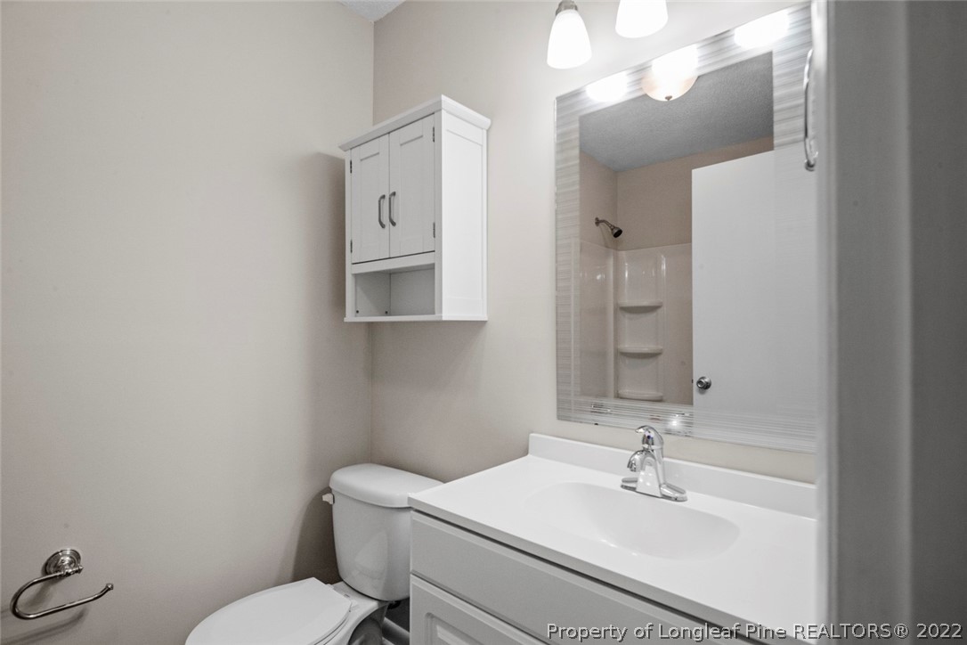 6614 Wake Forest Road Fayetteville, NC 28311 - Photo 31 of 48 a bathroom with a sink a toilet and mirror