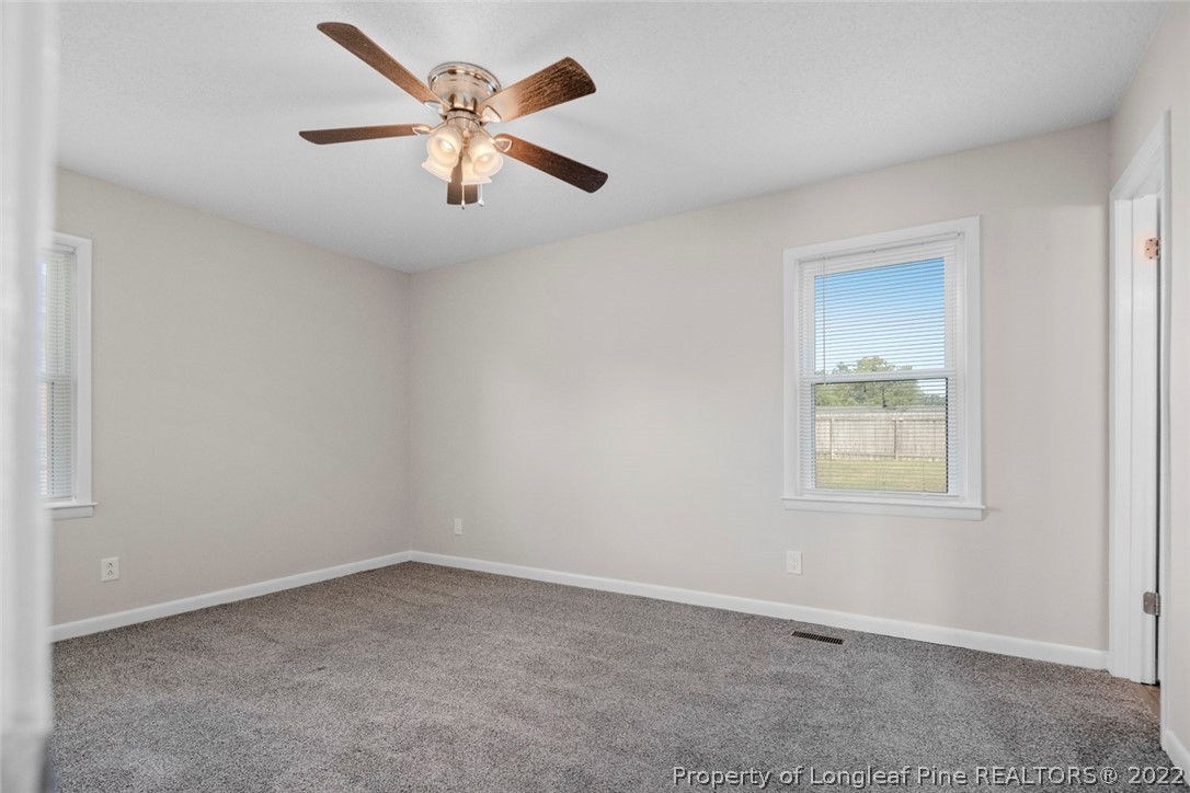 6614 Wake Forest Road Fayetteville, NC 28311 - Photo 38 of 48 an empty room with a window and a ceiling fan