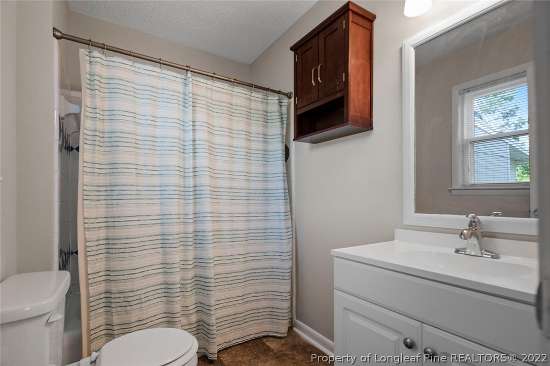 6614 Wake Forest Road Fayetteville, NC 28311 - Photo 41 of 48 a bathroom with a toilet a sink and mirror