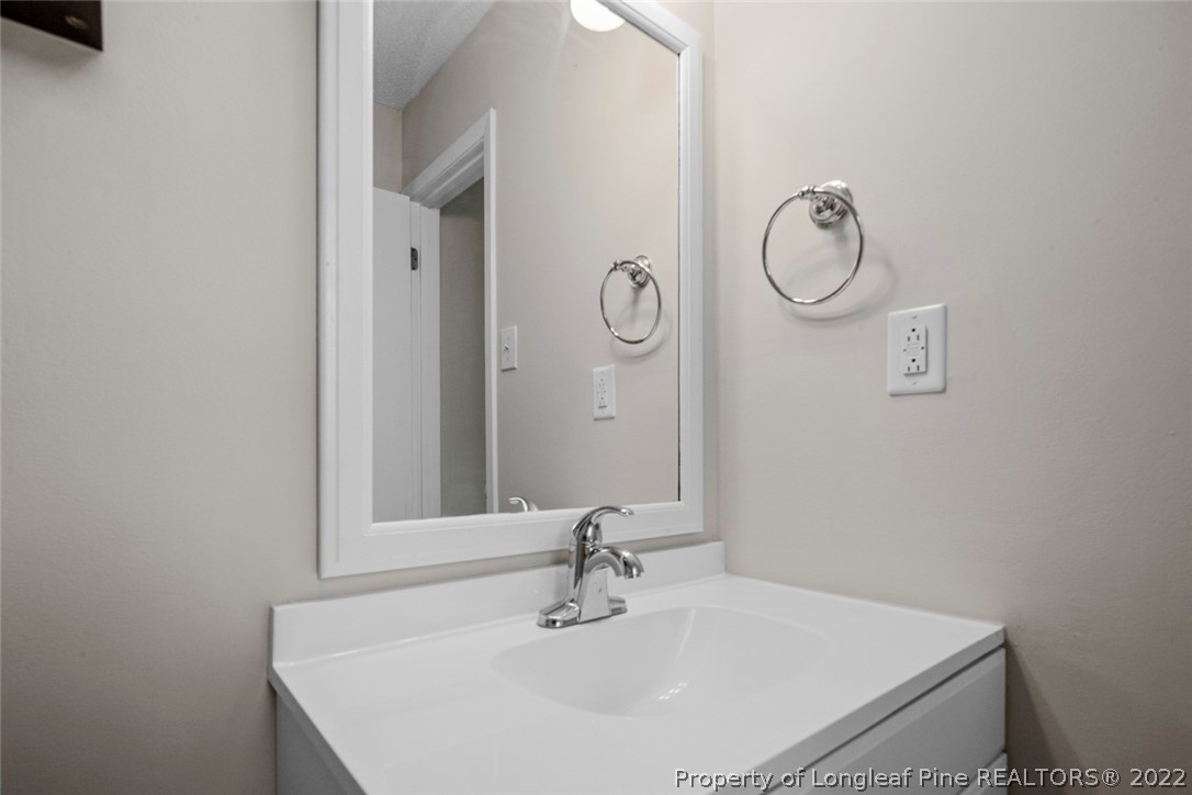 6614 Wake Forest Road Fayetteville, NC 28311 - Photo 43 of 48 a bathroom with a sink and mirror