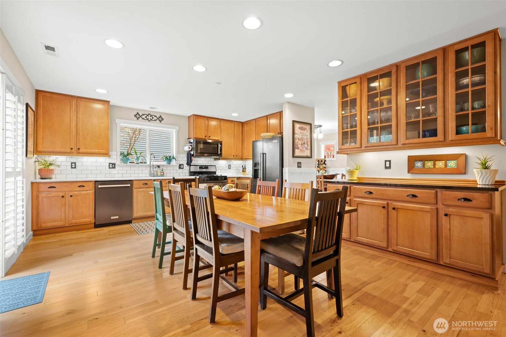 3114 Walker Road DuPont, WA 98327 - Photo 5 of 38 a kitchen with stainless steel appliances granite countertop wooden floor a dining table and chairs