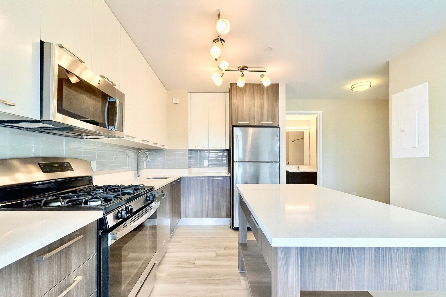1524 Sheepshead Bay Road, Unit 3C Brooklyn, NY 11235 - Photo 3 of 25 a kitchen with stainless steel appliances a stove microwave and refrigerator