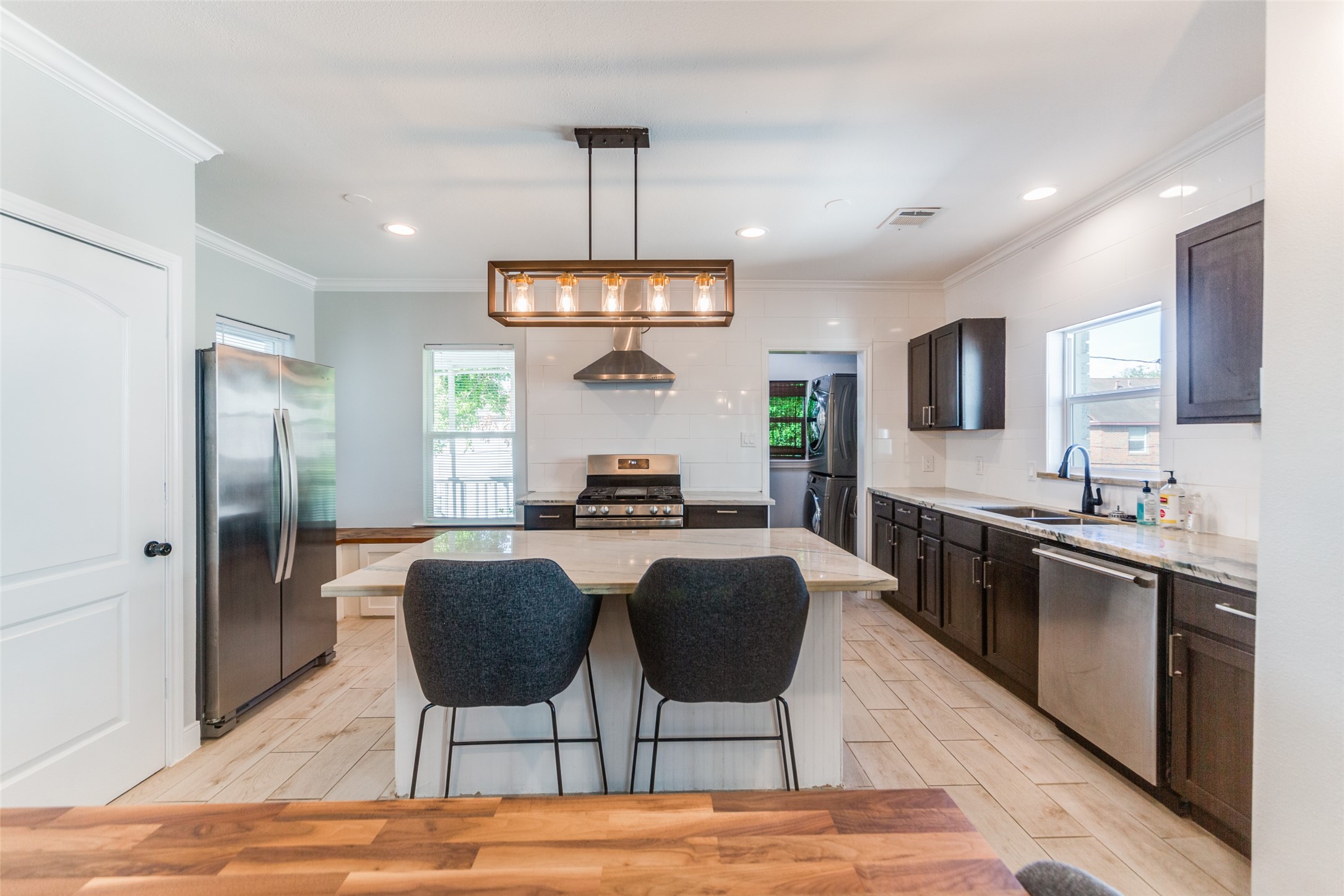 2410 Truxillo Street Houston, TX 77004 - Photo 17 of 41 Unit B (3-bedroom): Well-appointed kitchen anchored by a large center island with seating, quartz countertops, stainless appliances, and modern pendant lighting.