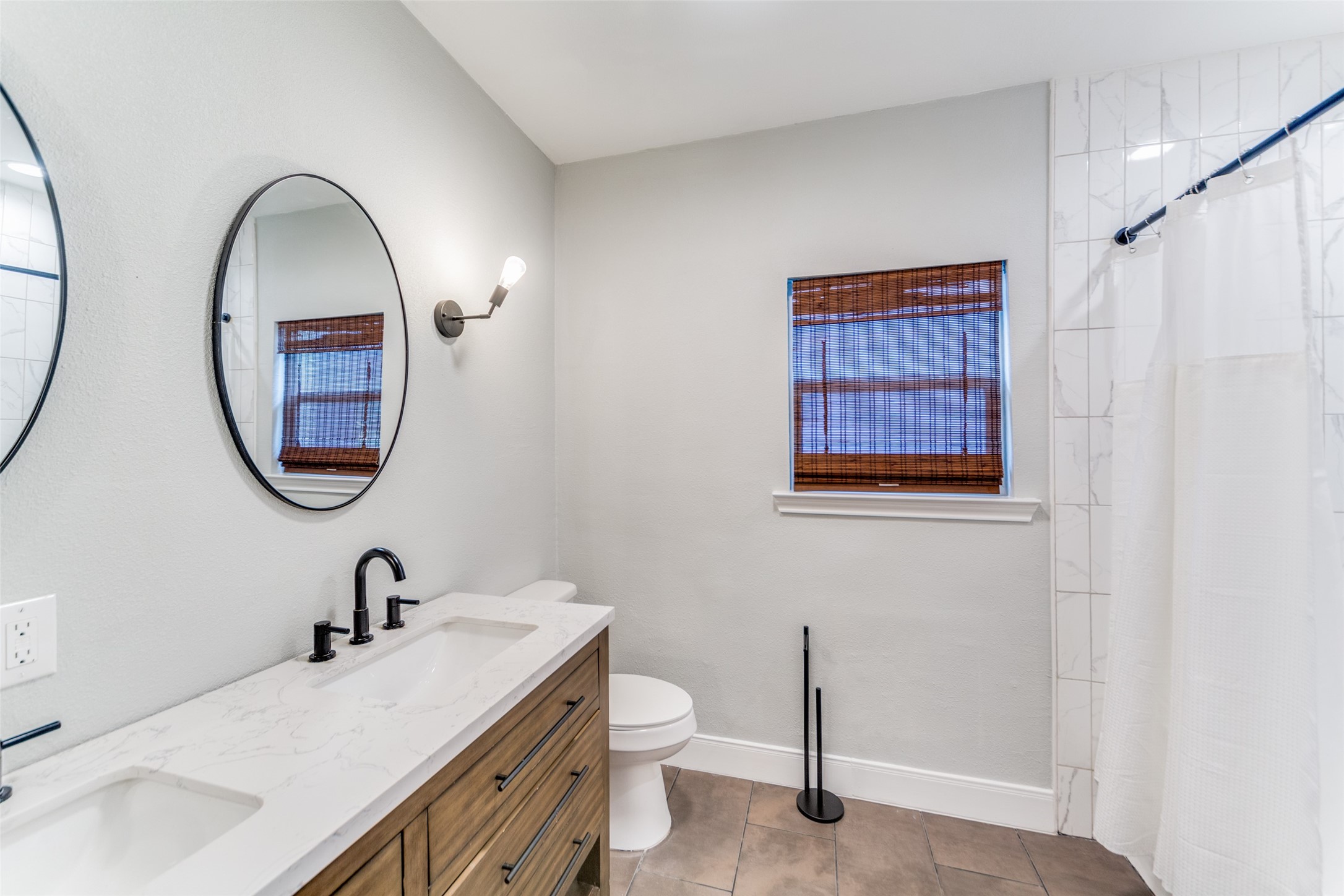 2410 Truxillo Street Houston, TX 77004 - Photo 26 of 41 Unit B (3-bedroom): Updated full bath showcasing dual-sink vanity with modern hardware, quartz countertop, and tub/shower combination with tile surround.