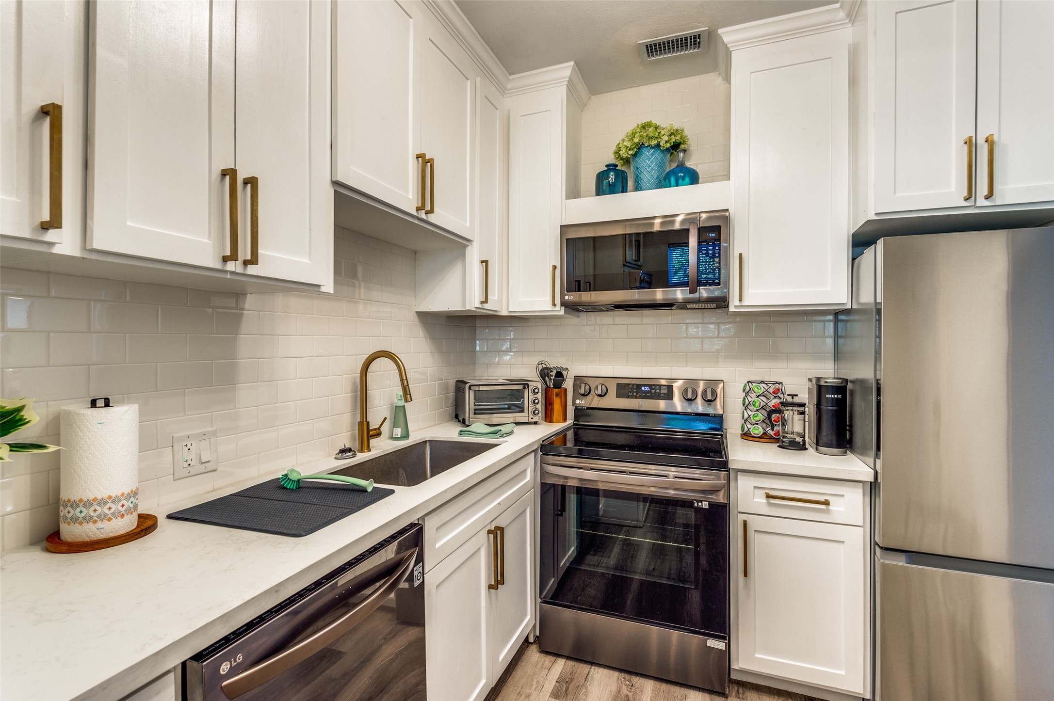 2410 Truxillo Street Houston, TX 77004 - Photo 29 of 41 Unit C (Studio): Efficiently designed U-shaped kitchen layout offers abundant cabinet storage, sleek stainless range, built-in microwave, and stylish open display niche for décor.