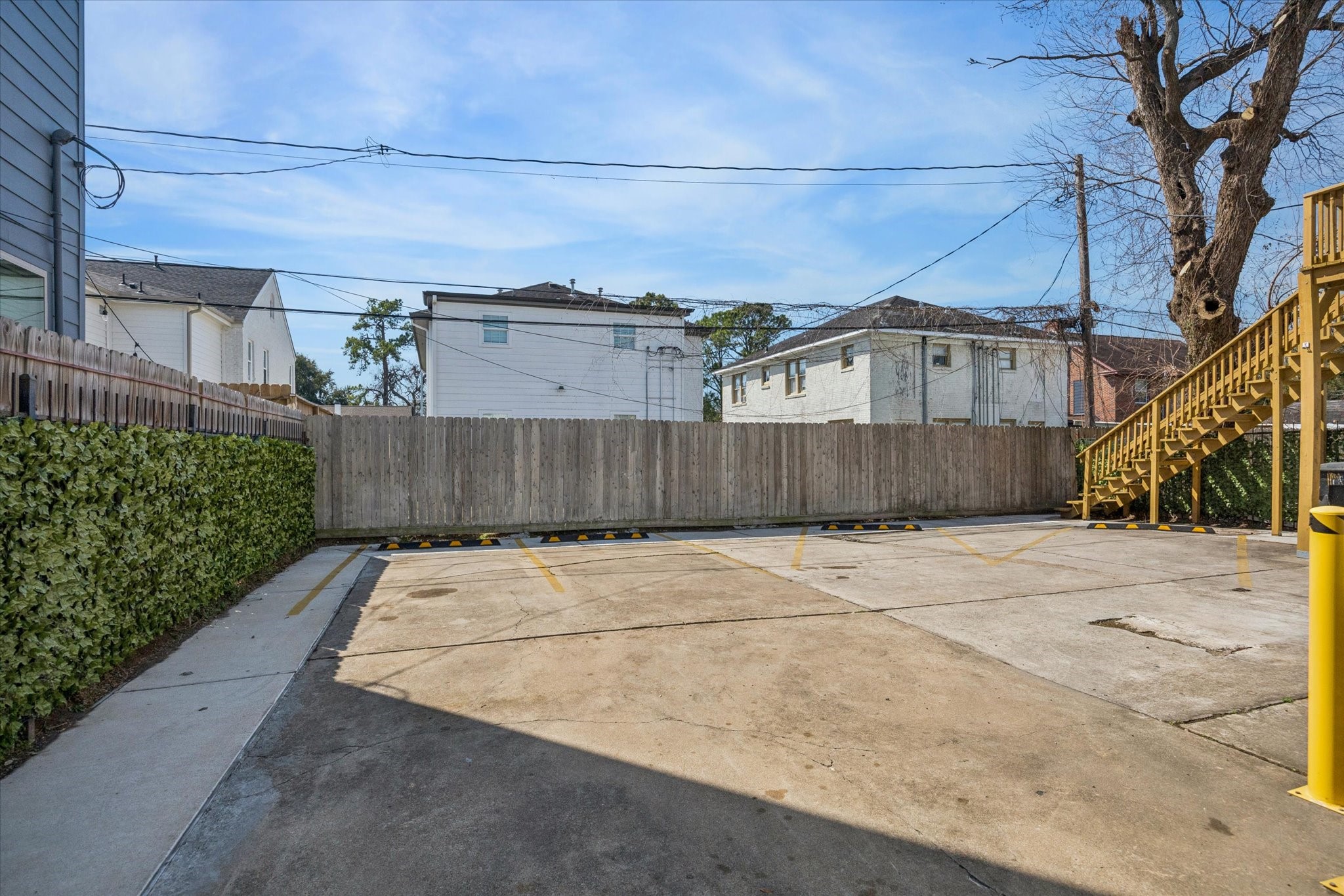 2410 Truxillo Street Houston, TX 77004 - Photo 38 of 41 Additional rear parking view showing organized parking layout, perimeter fencing, and exterior stair access to upper unit for functional multi-unit living.