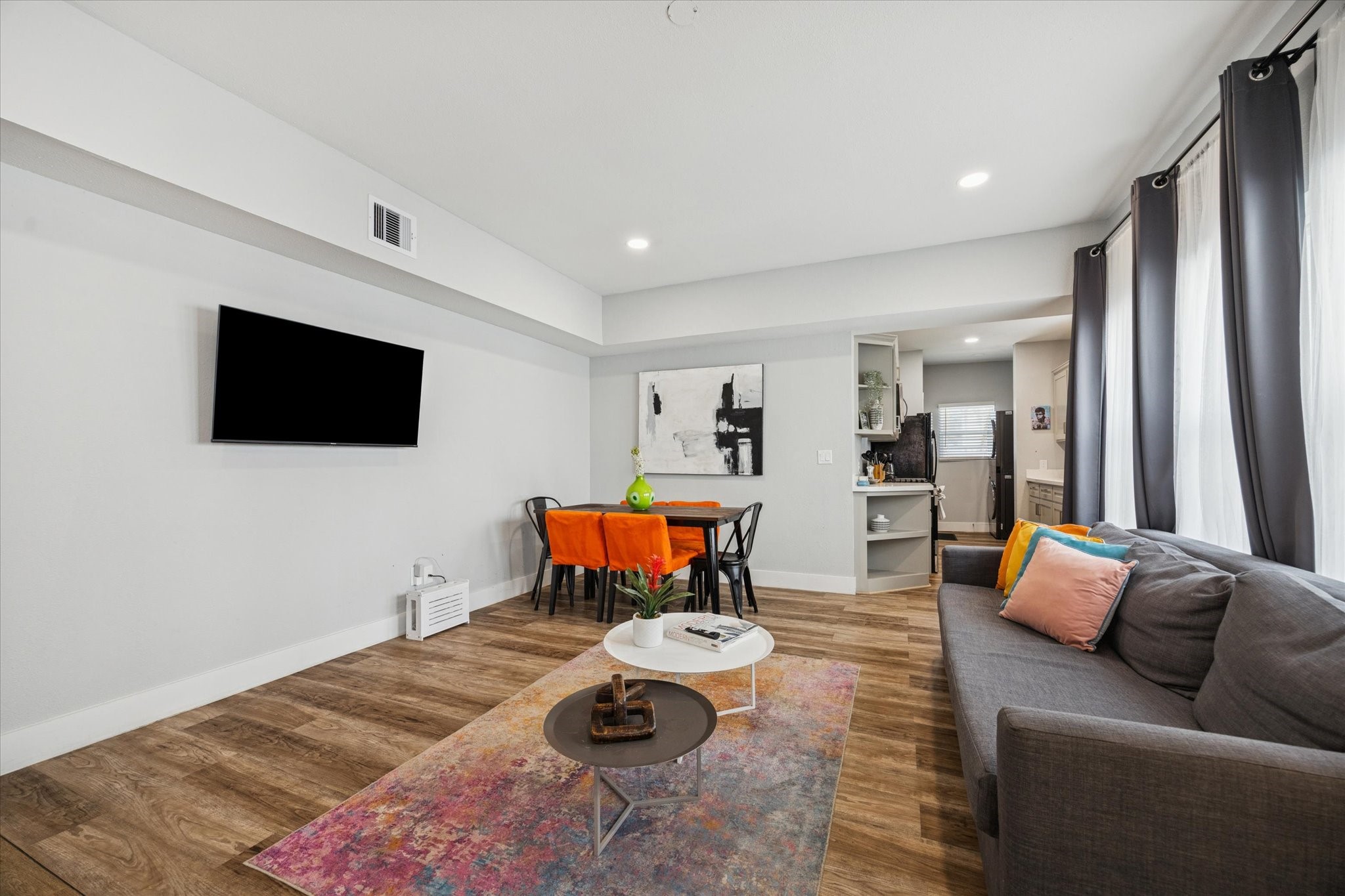 2410 Truxillo Street Houston, TX 77004 - Photo 5 of 41 Unit A (2-Bedroom): Comfortable living area with wide plank flooring, neutral color palette, and wall-mounted TV space creating a bright and inviting gathering space.