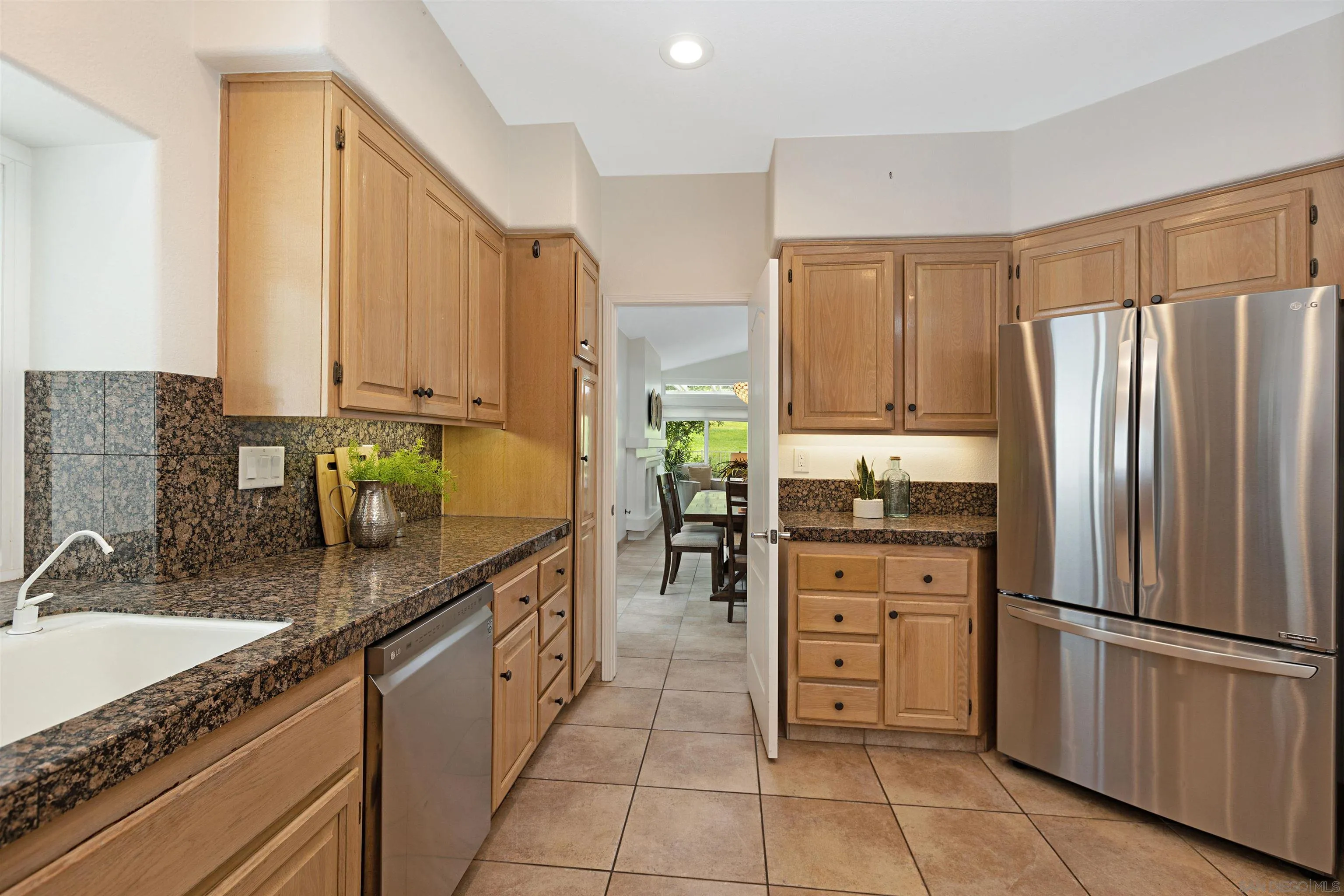 4158 Pindar Way Oceanside, CA 92056 - Photo 13 of 35 a kitchen with stainless steel appliances granite countertop a refrigerator a sink and white cabinets