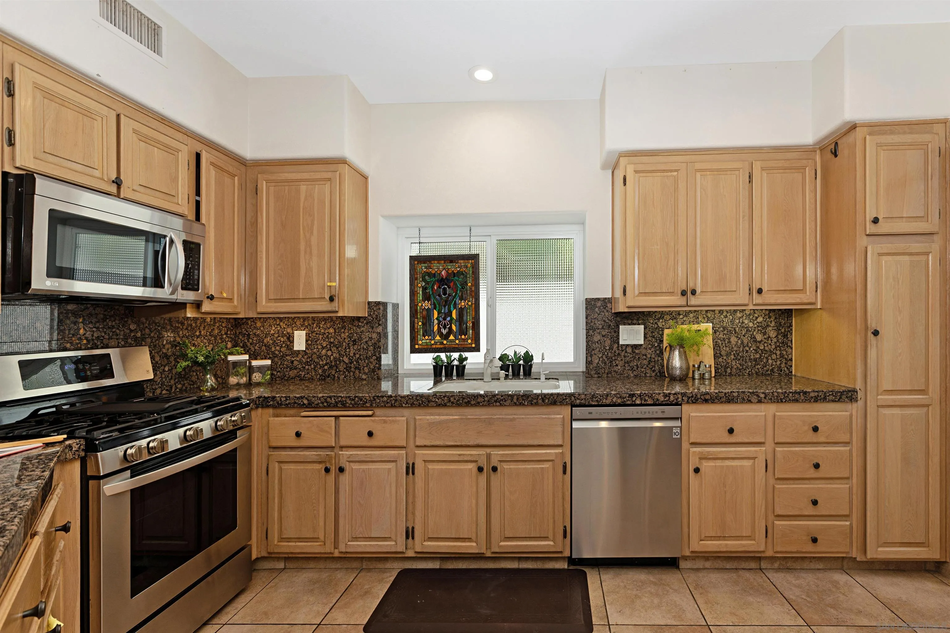 4158 Pindar Way Oceanside, CA 92056 - Photo 14 of 35 a kitchen with white cabinets and appliances