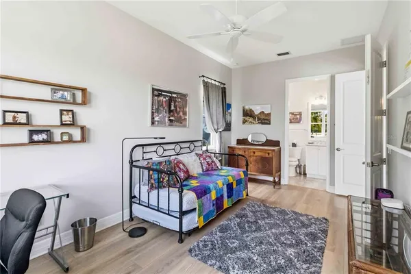 a bedroom with a bed wooden floor and a large window