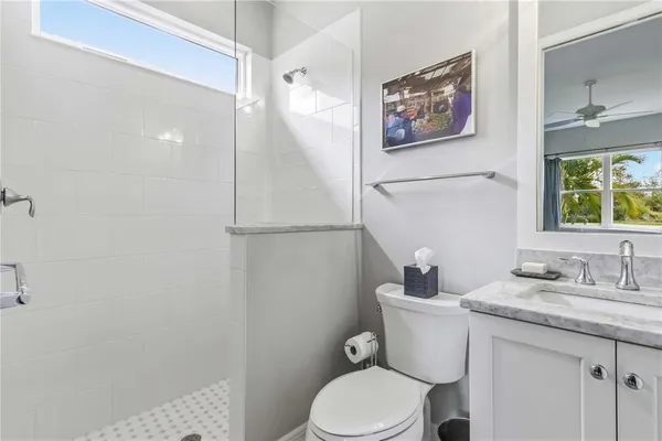 a bathroom with a granite countertop sink a toilet and a mirror
