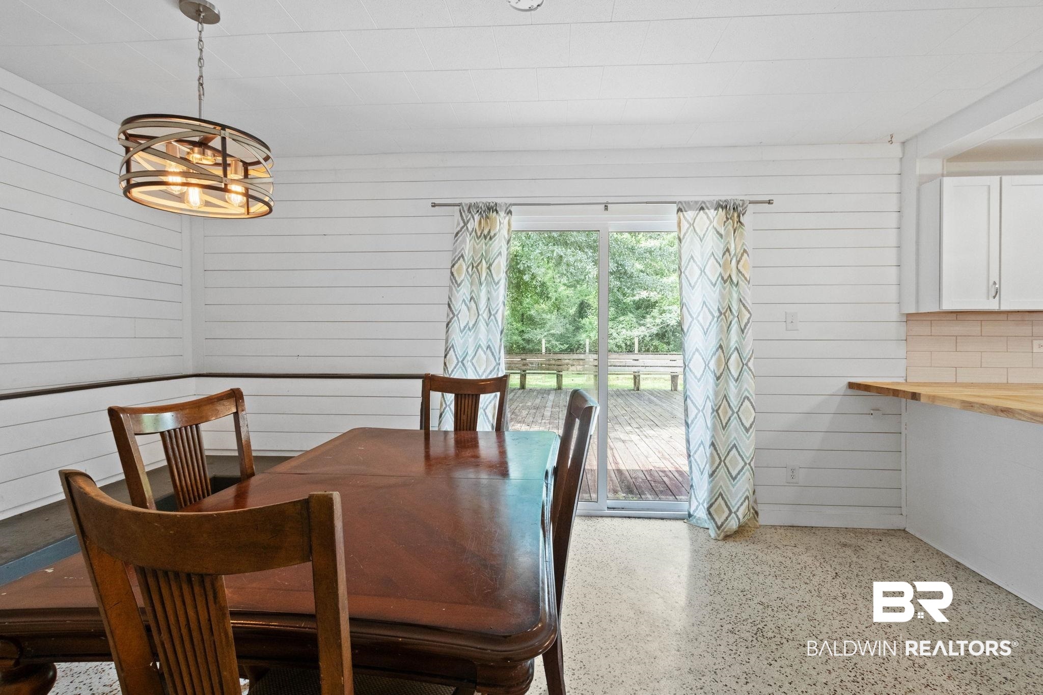 384 Old Bratt Road Atmore, AL 36502 - Photo 24 of 64 Dining area featuring white shiplap walls and a contemporary chandelier