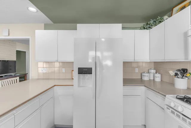 a view of living room with stainless steel appliances cabinets and chair