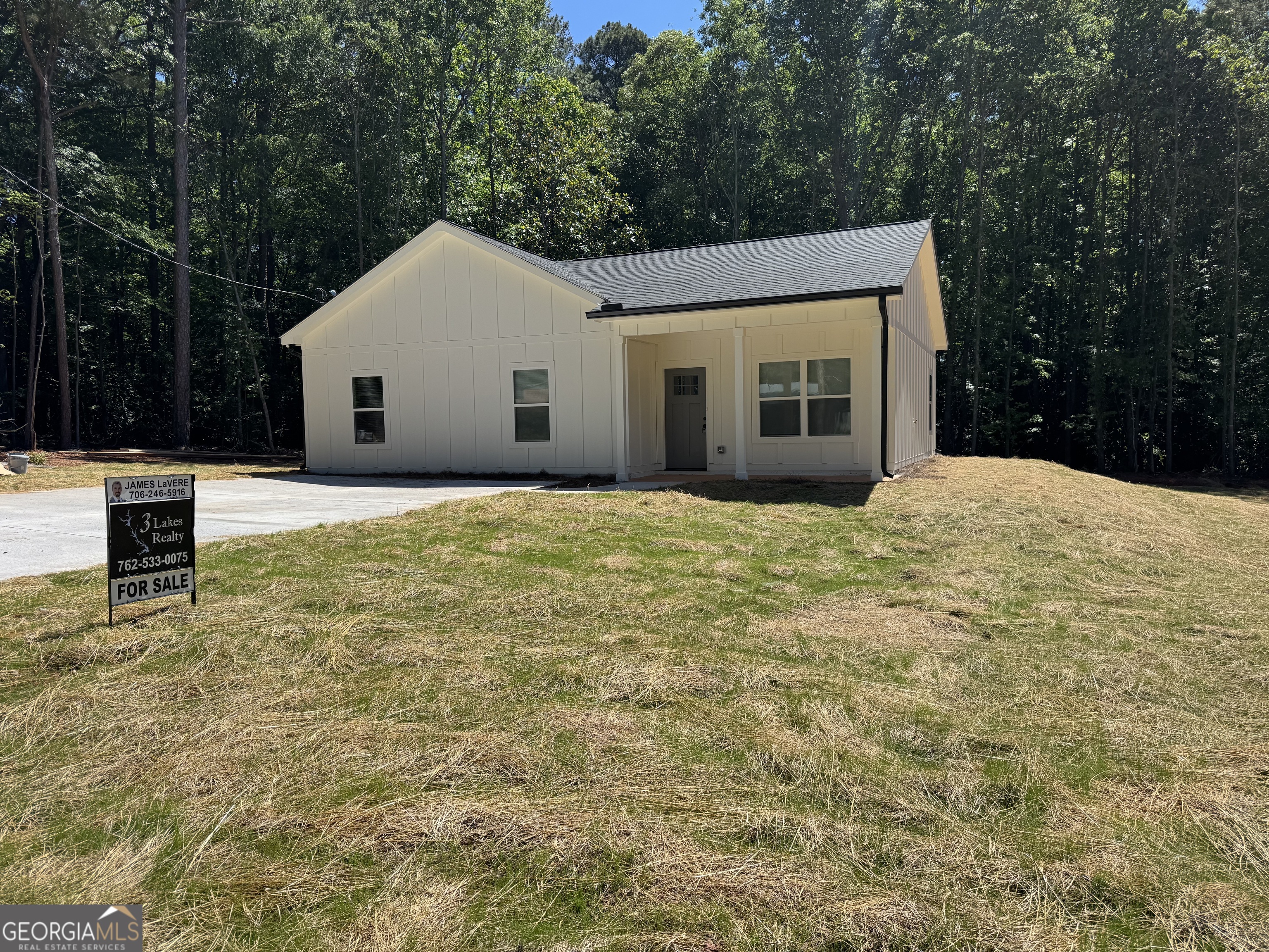 825 Mercer Drive Elberton, GA 30635 - Photo 2 of 22 a view of a white house with a yard and large trees