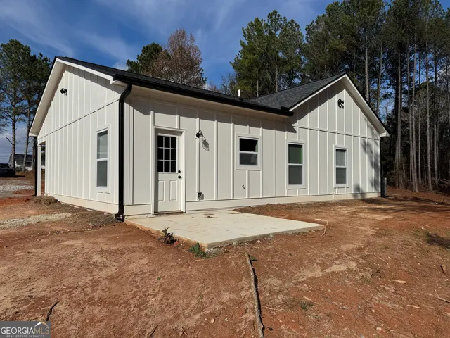 a view of a house with backyard and trees