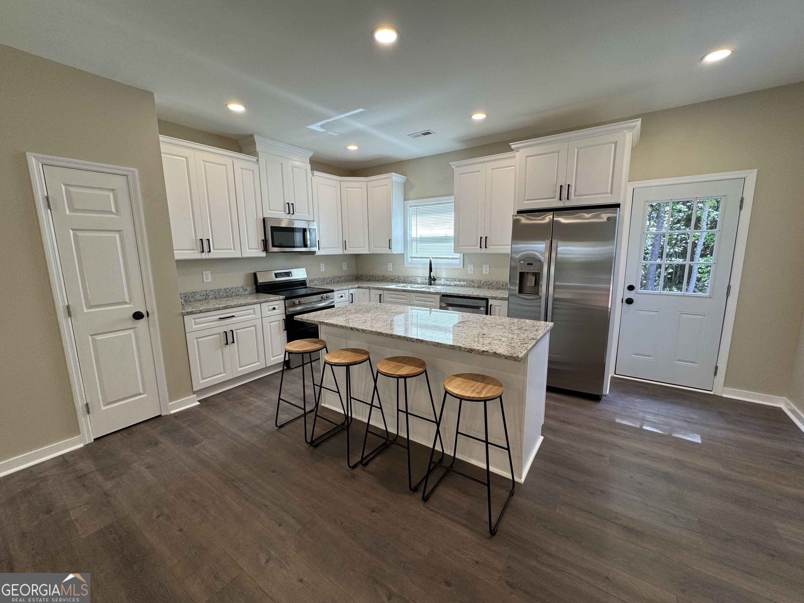 825 Mercer Drive Elberton, GA 30635 - Photo 4 of 22 a kitchen with stainless steel appliances granite countertop a refrigerator a stove top oven a sink and dishwasher with wooden floor