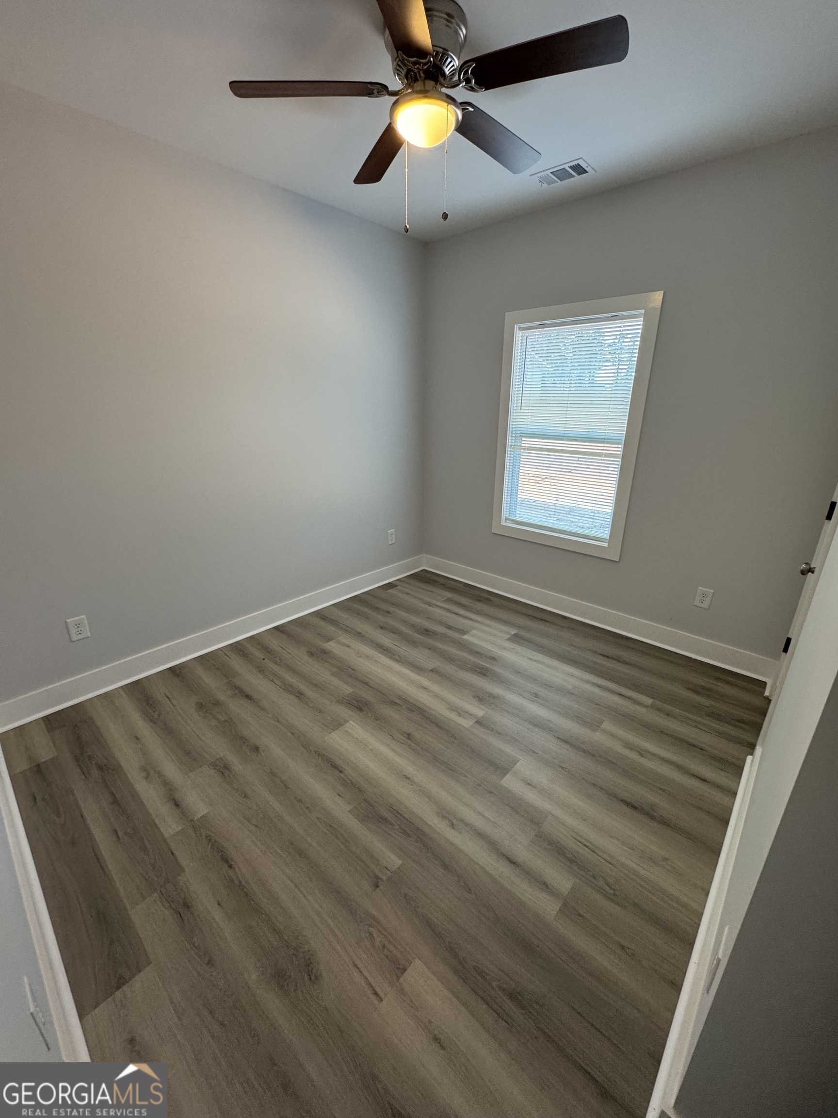 825 Mercer Drive Elberton, GA 30635 - Photo 9 of 16 an empty room with chandelier fan and windows