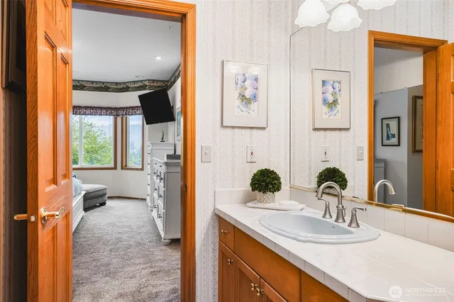 a bathroom with a granite countertop sink and a mirror