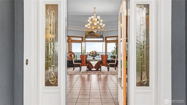 a view of a dining room with chandelier and glass door