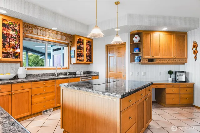 a kitchen with stainless steel appliances granite countertop a sink a counter space and a view of living room