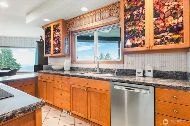 a kitchen with granite countertop sink stove and cabinets