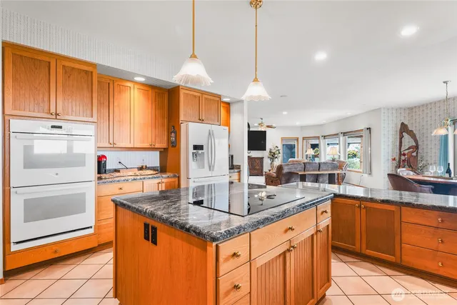 a kitchen with stainless steel appliances granite countertop a sink a stove and a refrigerator