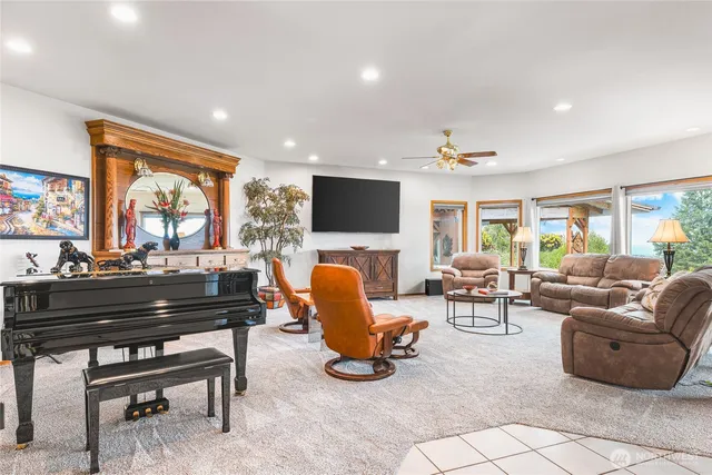 a living room with furniture fireplace and a large window