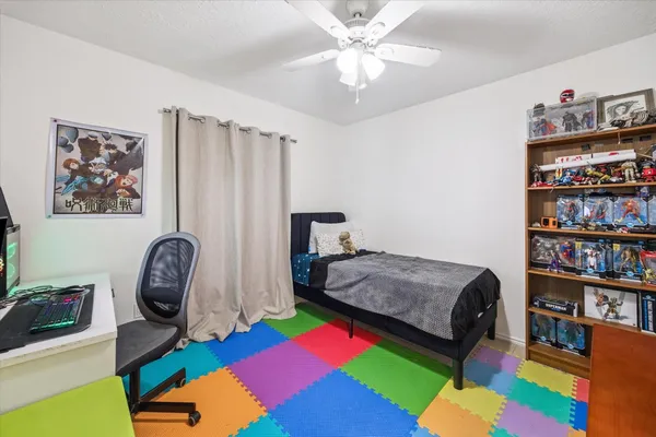 a bedroom with a bed bookshelf and a painting on the wall