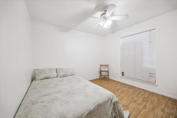 a bedroom with a bed and a ceiling fan