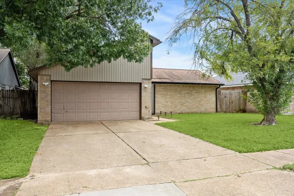 front view of house with a yard and trees