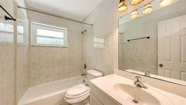 a bathroom with a sink a toilet a mirror a bathtub and shower