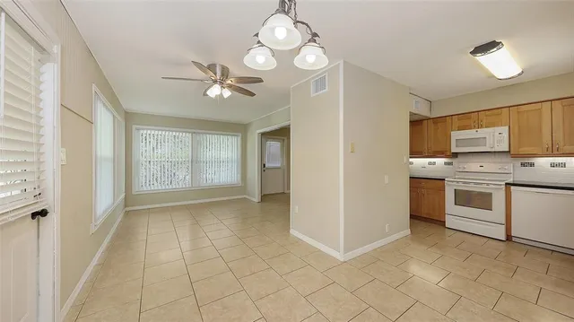 a view of a kitchen with a sink and dishwasher a refrigerator with white cabinets