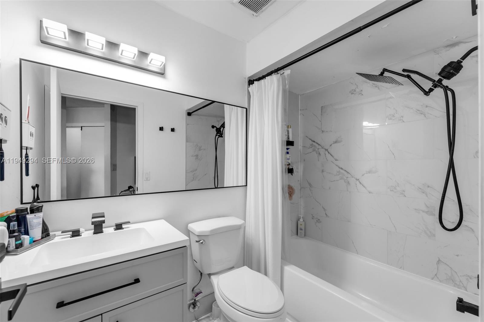 12909 Southwest 64th Lane Miami, FL 33183 - Photo 14 of 35 a bathroom with a sink a toilet and a mirror