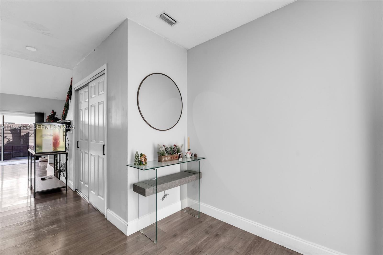 12909 Southwest 64th Lane Miami, FL 33183 - Photo 4 of 35 a room with a wooden floor and a mirror