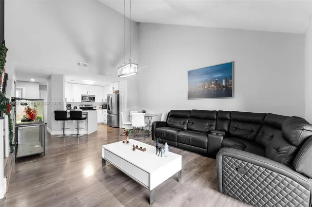a living room with furniture kitchen view and a table