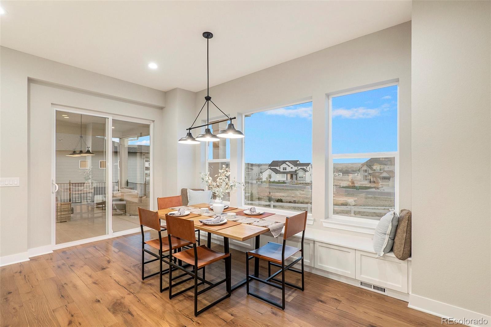 5828 Tesoro Point Parker, CO 80134 - Photo 13 of 43 a dining room with furniture a chandelier and wooden floor