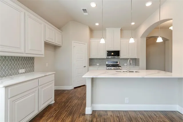 a kitchen with a sink stove and microwave