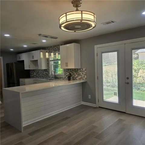 a large kitchen with stainless steel appliances a large counter top a stove and a window