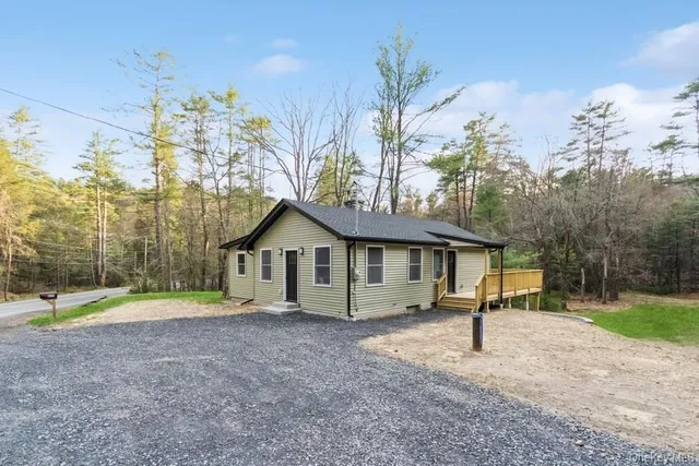 a front view of a house with a yard and trees